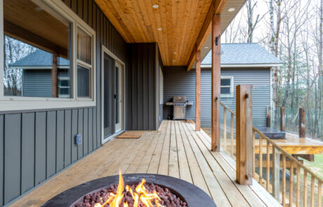 Back Porch living area with glass railings & grilling space